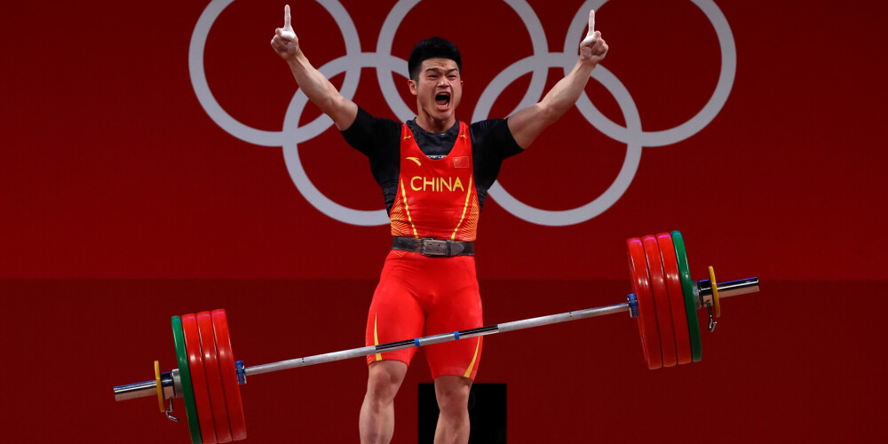Ši ar jaunu pasaules rekordu Ķīnai izcīna trešo uzvaru trešajās Tokijas olimpisko spēļu svarcelšanas sacensībās vīriešiem