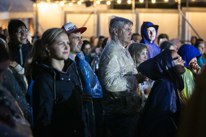 Jakās ar kapucēm un lietus plēvēs, cilvēki priecājas izbaudīt pilnvērtīga vasaras festivāla sajūtu.