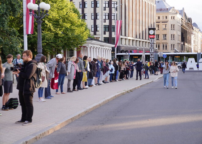 Daži desmiti vakcīnu pretinieku pie Brīvības pieminekļa uz 20 minūtēm sadodas rokās, protestējot pret "obligāto vakcināciju"