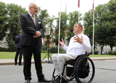 Valsts prezidents Egils Levits (no kreisās) un Latvijas valsts karoga nesējs paralimpisko spēļu atklāšanas ceremonijā Tokijā - paralimpietis diska mešanā Aigars Apinis.