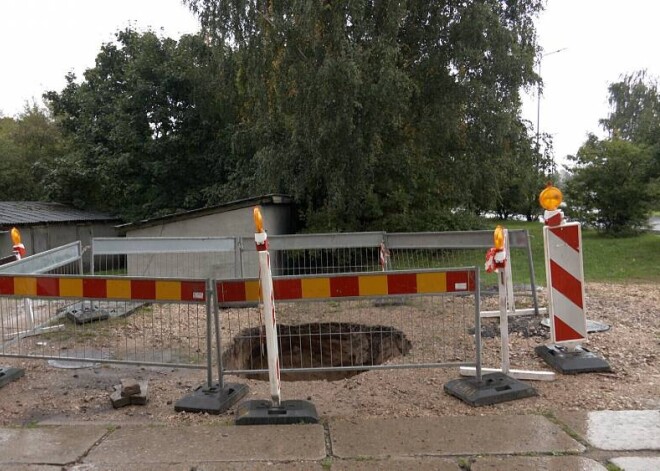 В Риге под асфальт почти провалилась машина: яма начала появляться на глазах жителей многоквартирного дома