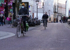 Cilvēki Amsterdamā brauc ar velosipēdiem.