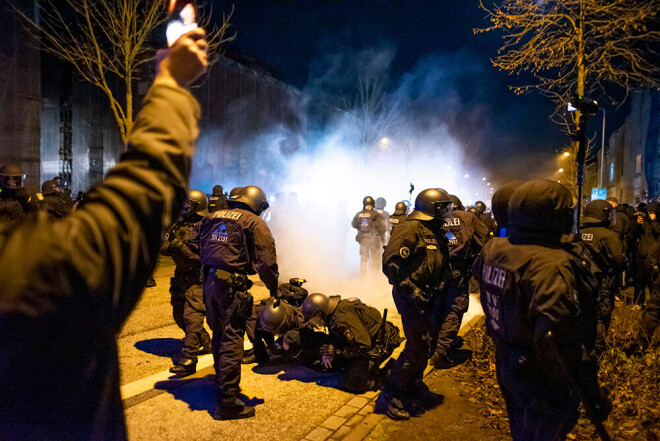 Policisti Rostokā aiztur protestētāju, kur notika demonstācijas pret jaunā koronavīrusa apkarošanas pasākumiem.