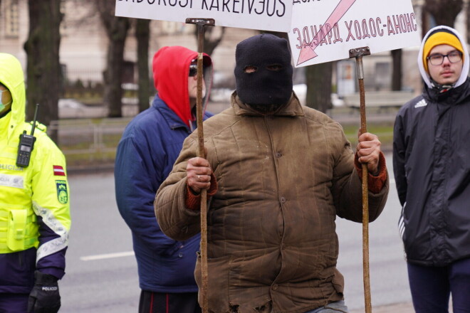 Ārpus pasākuma teritorijas uzturējās arī aktīvisti ar plakātiem.