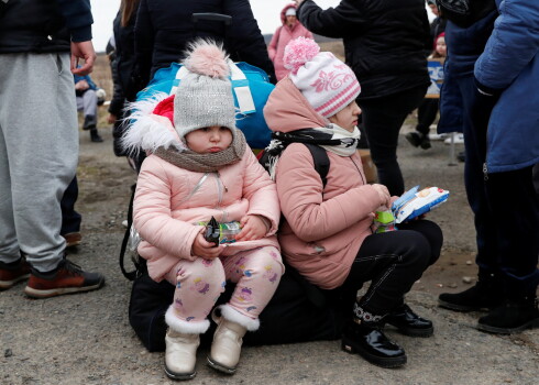 Bērni no Ukrainas sēž uz ģimenes mantām ieradušies Ukrainā.