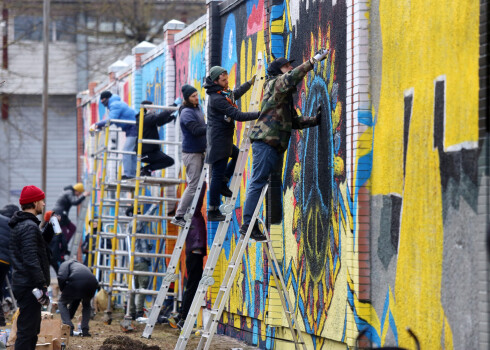 FOTO: mākslinieki Rīgā apglezno sienas, paužot atbalstu Ukrainai