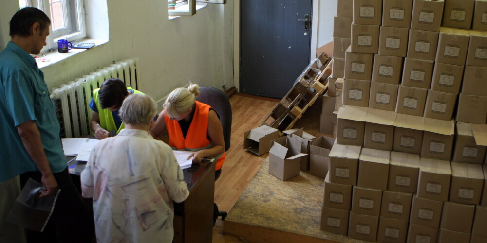 Cilvēki saņem pārtikas pakas trūcīgajiem biedrības "Latvijas Sarkanais Krusts" naktspatversmes telpās Gaiziņa ielā.