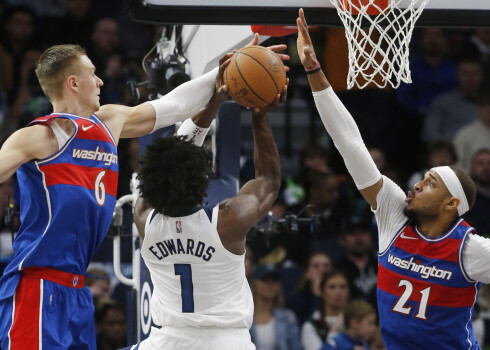 Kristaps Porziņģis un Daniels Gefords (pa labi) bloķē Entonija Edvardsa metienu.