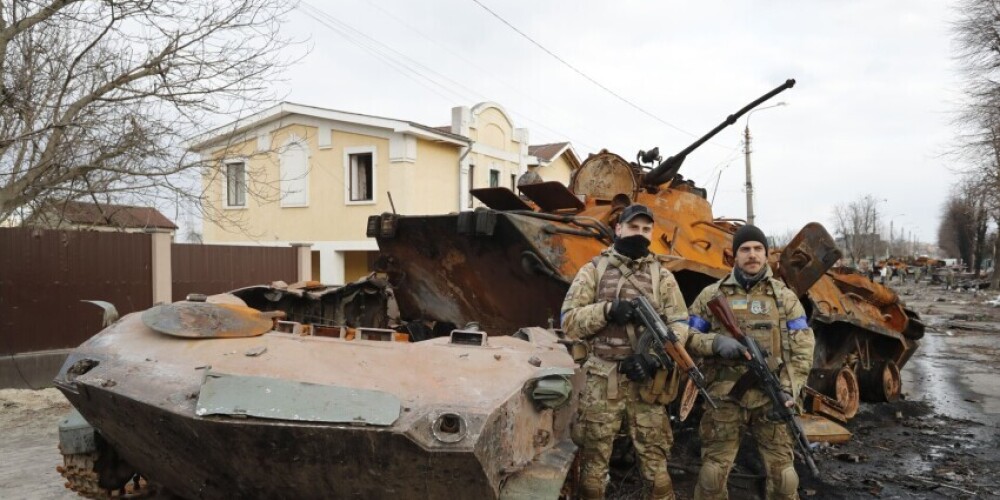 Ukraiņu armijnieki pie iznīcināta Krievijas armijas tanka Bučā. 