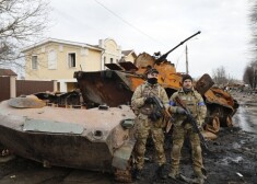 Ukraiņu armijnieki pie iznīcināta Krievijas armijas tanka Bučā. 