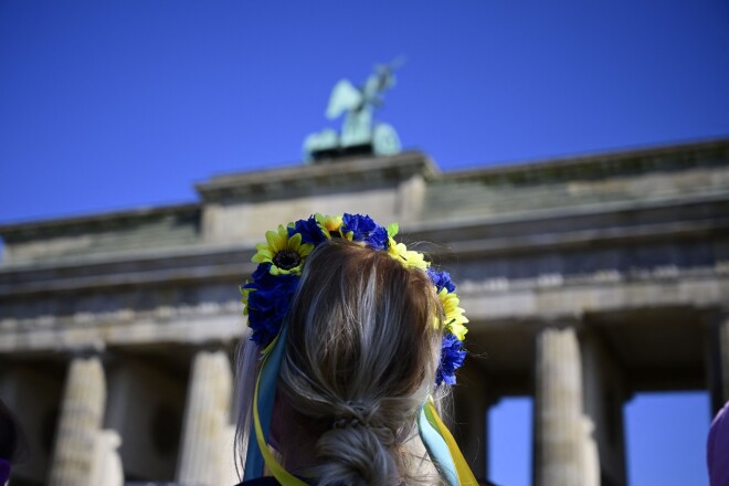 Meitene ar vainadziņu Ukrainas karoga krāsās pie Brandenburgas vārtiem Berlīnē, protestējot pret Krievijas sākto karu Ukrainā. 2022. gada 27. marts. 