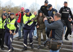 Valsts policijas darbinieki aiztur sievieti 10. maija vakarā pie pieminekļa Pārdaugavā, kur turpinās pulcēšanās un ziedu nolikšana.