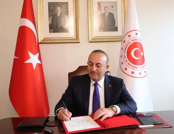 Turcijas ārlietu ministrs Mevlits Čavušoglu paraksta prasījumu Apvienoto Nāciju Organizācijai, kurā paģēr savas valsts nosaukumu mainīt no “Turkey” uz “Türkiye”.