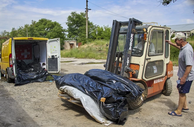 Īpašu uzdevumu komandas darbinieki iekrauj plastmasas maisus ar nogalināto Krievijas karavīru līķiem preču stacijā Harkivā, Ukrainā, 2022. gada 18. jūnijā. Harkiva ir Ukrainas otrā lielākā pilsēta, un tās apkārtne bija smagu kauju epicentrs ar upuriem abās pusēs.