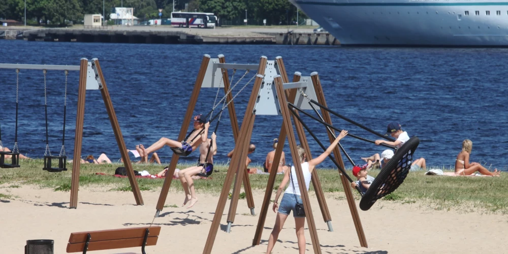 Cilvēki atpūšas Ķīpsalas pludmalē.