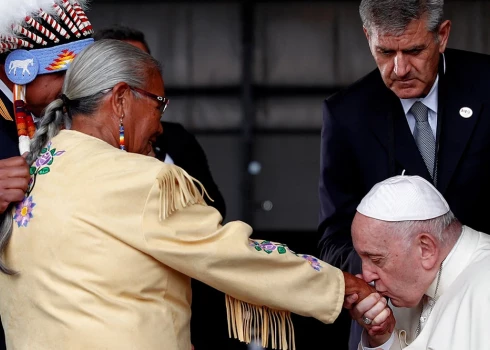 Pāvests Francisks sagaidīšanas ceremonijas laikā noskūpsta roku katoļu baznīcas pārraudzītajā ineternātskolā izdzīvojušajai Almai Dežarlē.