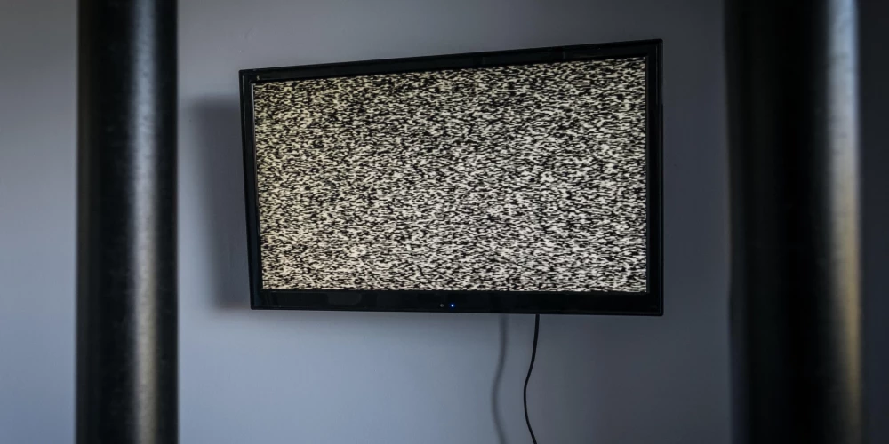 Televizors aiz restēm.