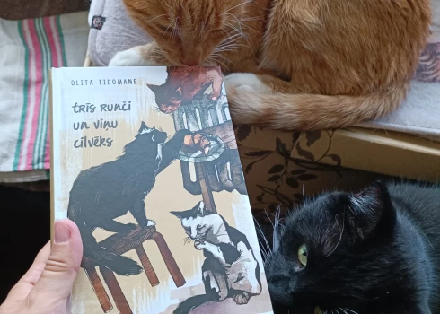 Runči Osvalds (no labās) un Rūdis iepazīst savu grāmatu.