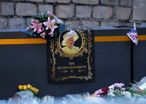 Люди несут цветы и свечи к Букингемскому дворцу