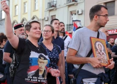 Protestētāja, kas tērpusies kreklā ar Krievijas prezidenta Vladimira Putina foto, dodas gājienā, lai protestētu pret starptautisko LGBTQ pasākumu Eiropride Belgradā.