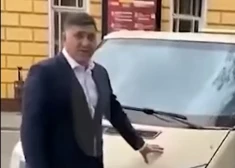 Сергей Пускепалис на фоне автомобиля, на котором попал в аварию