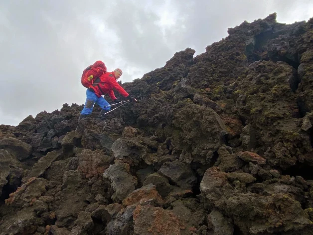 Rāpjoties pa vulkāna Eijafjadlajegidla krātera lavu Islandē.