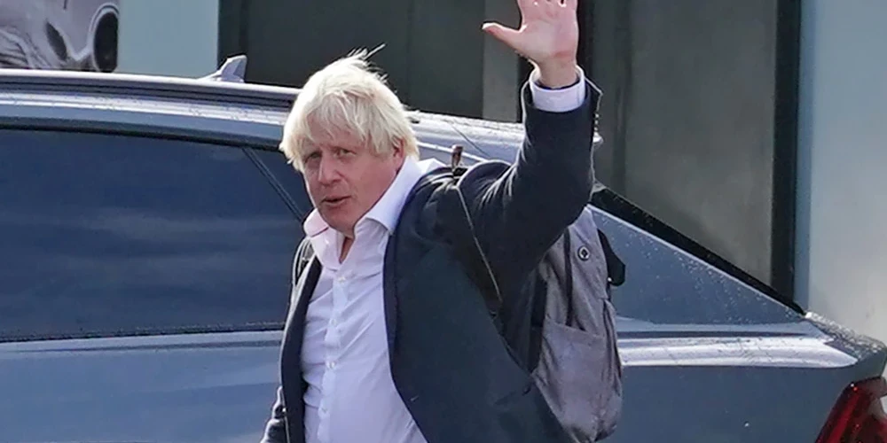 Boriss Džonsons sestdien atgriezies Londonā un Getvikas lidostā māj fotogrāfiem.