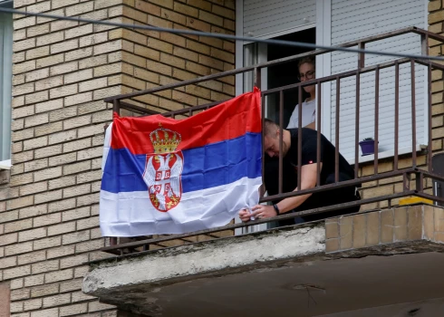 Kosovas pilsētā Ziemeļmitrovicā uz ēkas balkona izkārts Serbijas karogs 