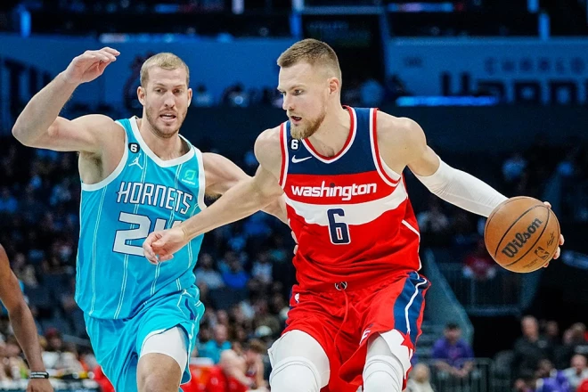 Kristaps Porziņģis mēģina apspēlēt "Hornets" centra spēlētāju Meisonu Plamlī. 