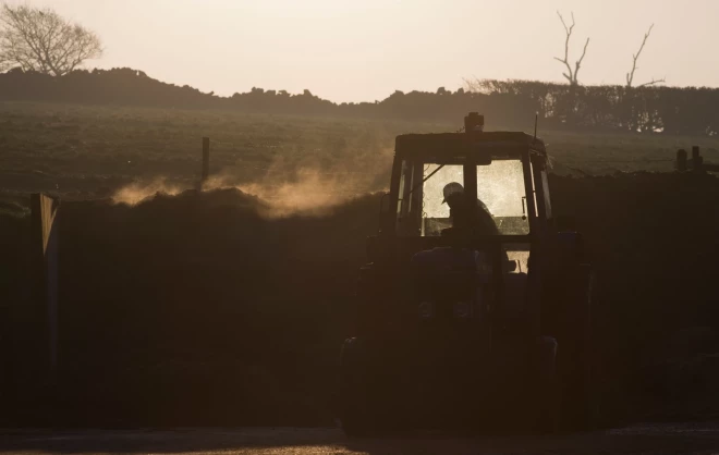 beautiful atmospBraucot pa Ventspils-Liepājas šoseju, kādam “merša” vadītājam tumšā vakara stundā nācās uzskriet virsū “neredzamam traktoram”.heric view of a farmer and tractor silhouetted in the dawn light on a farm in the uk