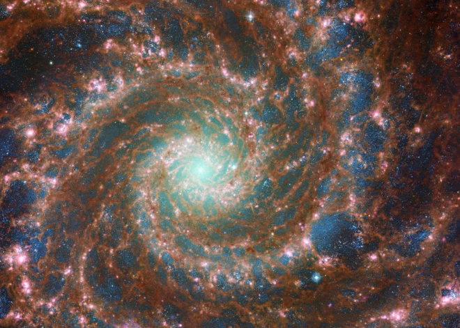 Kombinētajā optiskā/vidējā infrasarkanā attēla attēlā, kas ietver datus gan no NASA/ESA Habla kosmiskā teleskopa, gan NASA/ESA/CSA Džeimsa Veba kosmosa teleskopa, ir redzams M74, citādi pazīstams kā Fantoma galaktika, šajā izdales attēlā, kas tika publicēts 29. augustā.