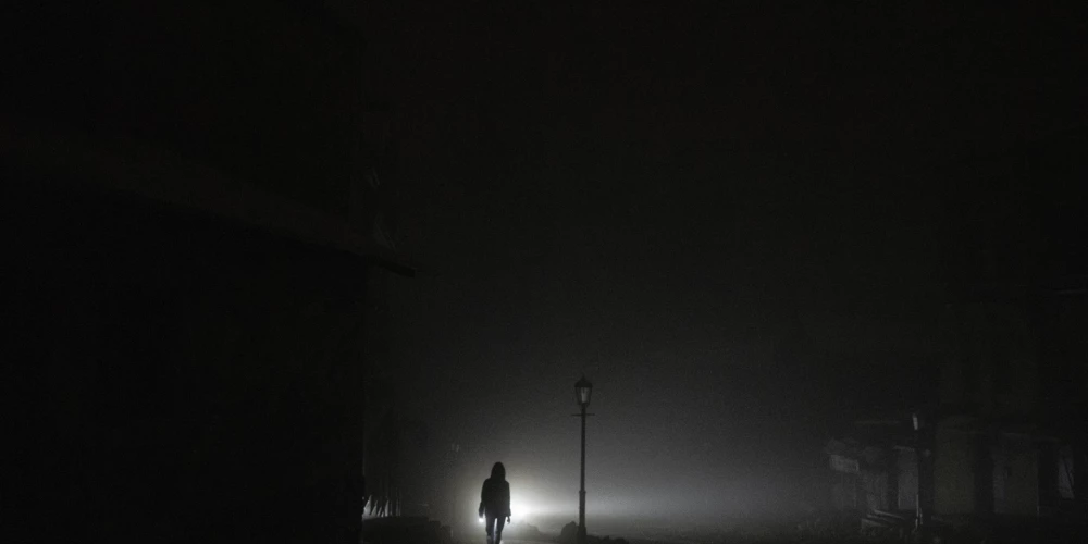 Kāda sieviete staigā pa pilsētas centru, kurai pēc vakardienas Krievijas raķešu uzbrukuma Kijevā, Ukrainā, ceturtdien, novembrī, pazuda elektrība. 24 novembris, 2022. gads.