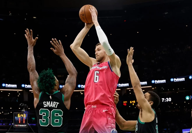 Kristaps Porziņģis mēģina atdot piespēli pāri "Celtics" aizsarga Markusa Smārta (#36) rokām.