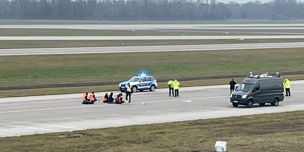 Klimata aktīvisti izgriezuši žogā caurumu un pielīmējušies pie skrejceļa Minhenes lidostā