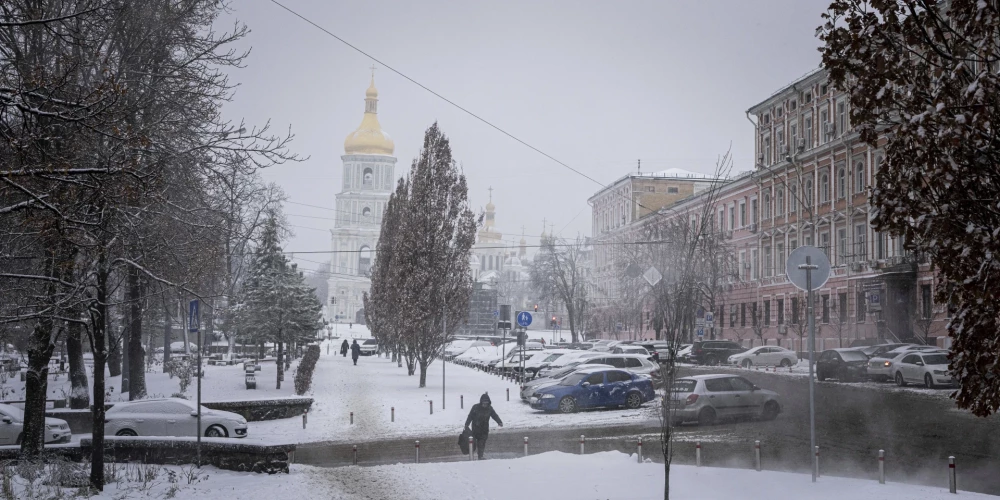 Sieviete staigā pa ielu Kijivas pilsētas centrā, Ukrainā, ceturtdien, 2022. gada 15. decembrī.