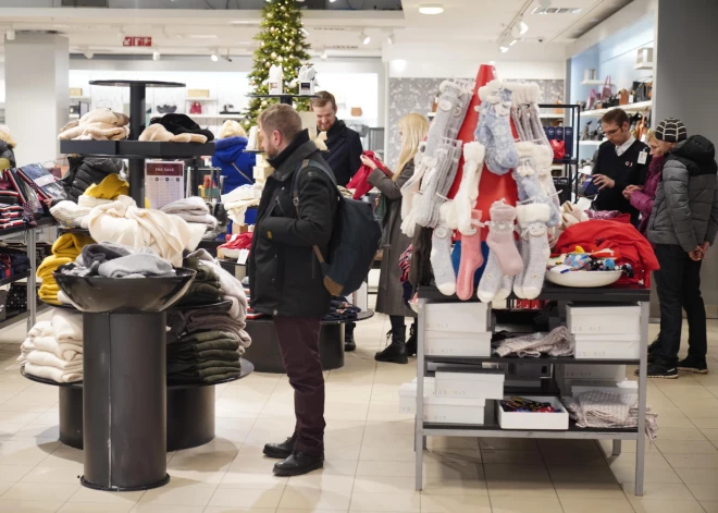 FOTO: pirmssvētku duna pie veikalu plauktiem. Pircēji lūkojas pēc dāvanām un satiek arī Ziemassvētku vecīti