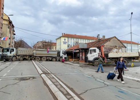 Trešdien, 2022. gada 28. decembrī, cilvēki iet gar nesen uzceltu ceļa blokādi Bosniešu kvartālā netālu no Mitrovicas tehniskā skolas ziemeļos, Kosovā.