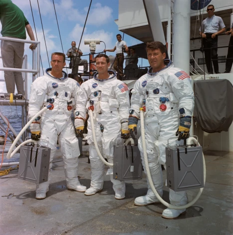 ASV: 1968. gada augusts. Pirmās pilotējamās "Apollo" kosmosa misijas "Apollo 7" galvenā komanda atrodas uz NASA motorkuģa retrīvera klāja pēc tam, kad ir sagatavojusies ūdens izplūdes apmācībai Meksikas līcī. No kreisās uz labo pusi ir astronauti VALTERS KANNINGEMS, DONS AIsels un VALTERS ŠĪRS. 