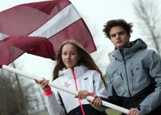 Marija Seļiverstova un Linards Reinis Laizāns ar Latvijas karogu.