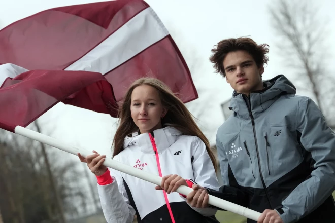 Marija Seļiverstova un Linards Reinis Laizāns ar Latvijas karogu.