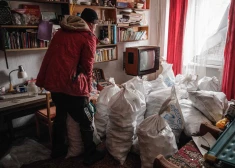 Vietējais iedzīvotājs Oleksijs uz kaimiņa  dzīvokli Bahmutā atnes malkas maisu. 2023. gada 1. februāris.