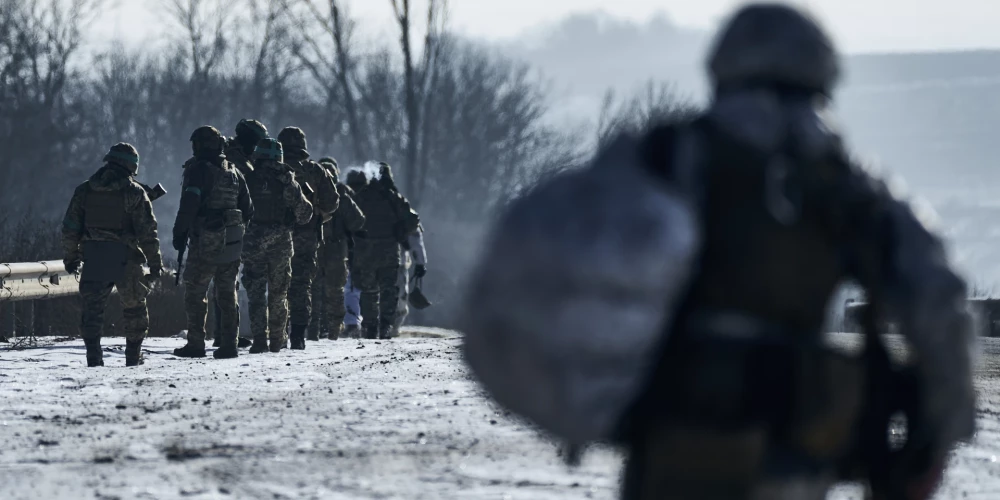 Ukrainas karavīri dodas savās pozīcijās frontes līnijā tuvu Bahmutai, Doneckas reģionā. 2023. gada 8. februrāris.