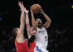 Bruklinas Nets aizsargs Spensers Dinvidijs pret Čikāgas Bulls centru Nikola Vučeviču, pa kreisi, NBA basketbola spēles pirmajā puslaikā, ceturtdien, 2023. gada 9. februārī, Ņujorkā. 