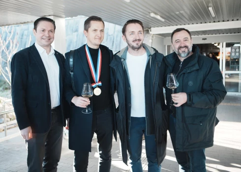 FOTO: ar dzērieniem Rīgas lidostā sagaida pasaules vīnziņu čempionāta uzvarētāju latvieti Raimondu Tomsonu