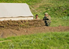 Azerbaidžānas armijas karavīrs tēmē savu šaujamieroci uz Armēnijas karavīru pozīcijām.