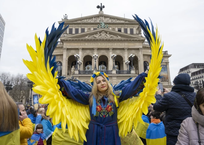 Izgaismoti nami Ukrainas karoga krāsās un demonstrācijas - cilvēki visā pasaulē piemin kara gadadienu