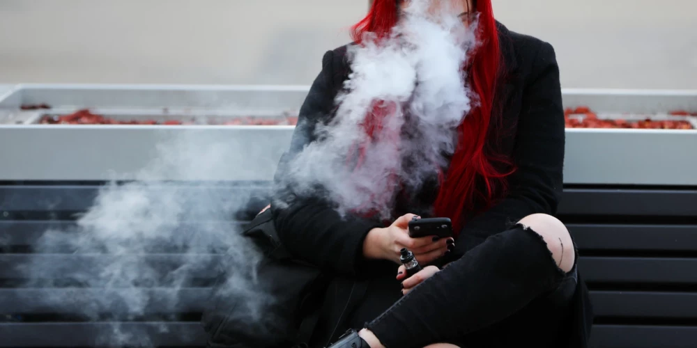 Sieviete smēķē elektronisko cigareti.
