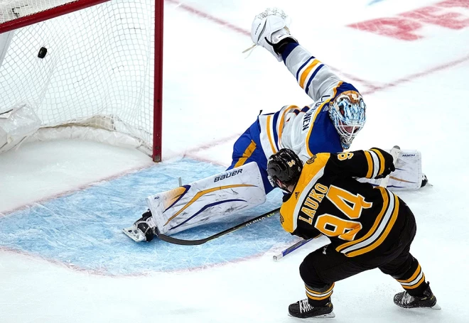 "Bruins" uzbrucējs Jakubs Lauko otrajā trešdaļā pārspēj "Sabres" vārtsargu Uko Peku Lūkonenu.