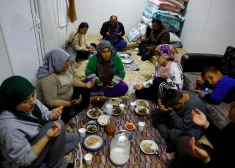 Members of the Arslan family pray at dinner in one of the three container homes where they live by a petrol station after losing their homes in the aftermath of a deadly earthquake in Nurdagi, Turkey, March 4, 2023. REUTERS/Susana Vera