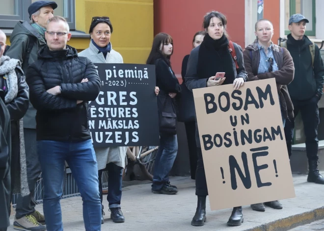 Šorīt aptuveni 80 cilvēku, tajā skaitā Latvijas muzeju biedrības pārstāvji, kultūras darbinieki, partiju "Par!" un "Progresīvie" biedri, pulcējušies pie Vides aizsardzības un reģionālās attīstības ministrijas (VARAM), prasot atlaist Ogres mēru Egilu Helmani (NA).